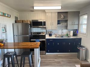 een keuken met blauwe kasten en een houten tafel bij Egret in Holden Beach