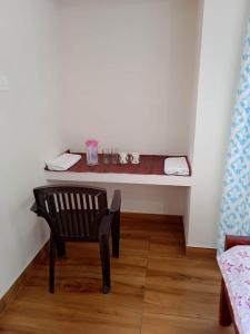 einen kleinen Tisch mit Stuhl in einem Zimmer in der Unterkunft Hilton Hill in Varkala