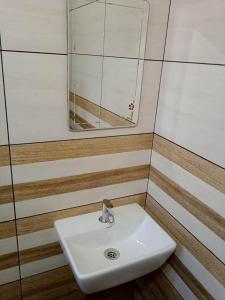 ein weißes Waschbecken in einem Badezimmer mit einem Spiegel in der Unterkunft Hilton Hill in Varkala + 29 Fotos