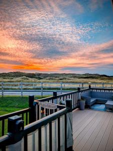 eine Terrasse mit Blick auf das Meer bei Sonnenuntergang in der Unterkunft Peacehaven, Ynyslas, Borth in Borth