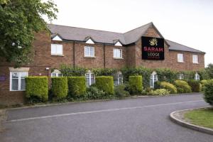 a building with a sign for a sahm lodge at Saram Lodge Lichfield in Lichfield