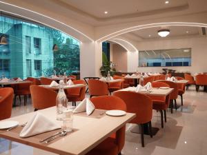 a restaurant with tables and chairs and a large window at The Fern Habitat Pune, Mundhwa, Series by Marriott in Pune
