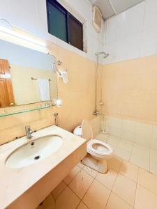 a bathroom with a sink and a toilet and a mirror at Royal Continental in Islamabad +26 photos