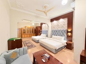 a bedroom with two beds and a couch at Royal Continental in Islamabad
