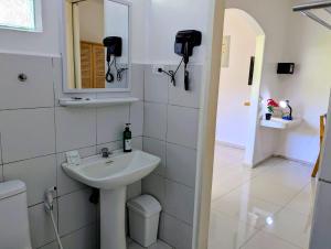 a white bathroom with a sink and a mirror at Astillo's Guest Houses in Moalboal
