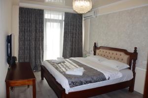 a bedroom with a bed and a desk and a window at Hotel Kochana in Chʼkhorotsqu