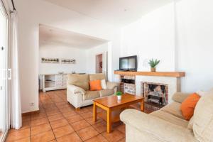 Una sala de estar con dos sofás y una chimenea. en Villa Casa de Olives, en Cala Galdana