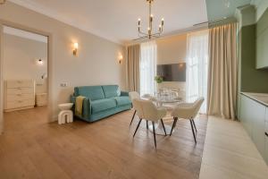 尼斯Aparthotel 9 ALBERTI Nice Centre的客厅里有一张桌子和一张蓝色沙发