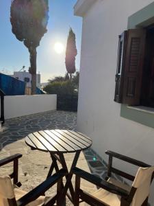 a table and two chairs next to a building with a table at Vivazoi Ousia studio # 3 in Leipsoi