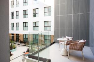 a balcony with a table and chairs and a building at Líbere Seville Plaza Nueva in Seville