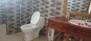 a bathroom with a toilet and a sink at Kua Garden Bungalow in Utende +35 photos