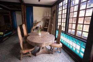 einen Holztisch und Stühle in einem Zimmer mit Fenstern in der Unterkunft Porto Marlin Hotel in Conceição da Barra