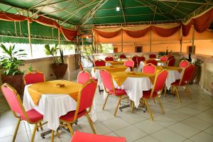 um restaurante com mesas e cadeiras em uma sala em Sagas Hotel ltd em Nairobi