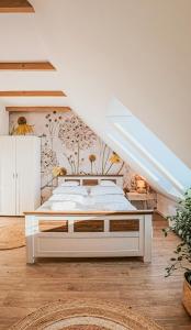 una camera da letto con un grande letto bianco in una stanza di Lawendowe Rancho a Szczytna