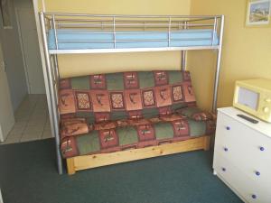 a bedroom with a bunk bed with a bedspread on it at Résidence Au Petit Chamois in Le Corbier