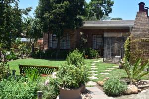 een tuin met planten voor een huis bij Siesta B&B in Vryheid +32 foto's