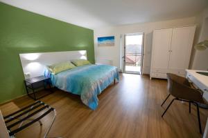 a bedroom with a bed and a green wall at B&B Anele in Morano Calabro