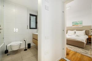 Un dormitorio con una cama y un baño con inodoro. en ULIVE Boutique ApartHotel, en Tel Aviv 218 fotos más