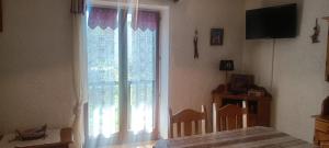 Habitación con ventana grande y TV. en Nice studio in the heart of Le Monêtier-les-Bains, en Le Monêtier-les-Bains