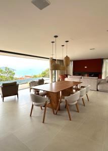 una sala da pranzo con tavolo e sedie in legno di Casa Céu do Siriú a Garopaba