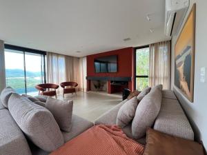 a living room with a couch and a television at Casa Céu do Siriú in Garopaba