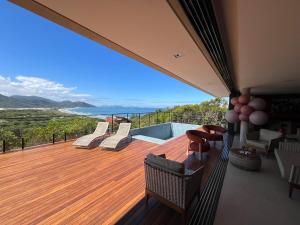 una terrazza con sedie e vista sull'oceano di Casa Céu do Siriú a Garopaba
