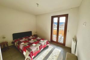 ein Schlafzimmer mit einem Bett und einem großen Fenster in der Unterkunft T3 apartment with balcony in Briançon in Briançon
