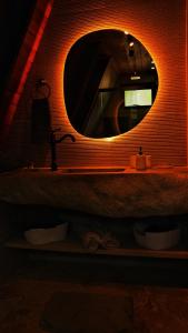 a bathroom with a round mirror and a sink at Cabana Sol do Norte in Brumadinho