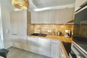 eine Küche mit weißen Schränken und einer Spüle in der Unterkunft T3 apartment with balcony in Briançon in Briançon + 8 Fotos