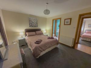 ein Schlafzimmer mit einem Bett, auf dem zwei Handtücher liegen in der Unterkunft Tamh Cottage in Tarbert