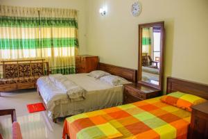 a bedroom with two beds and a mirror at Satyodaya Educational Training Centre in Kandy +54 photos