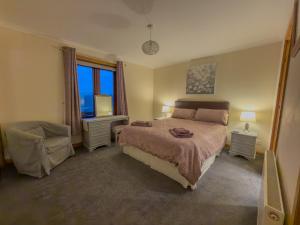 ein Schlafzimmer mit einem großen Bett und einem Fenster in der Unterkunft Tamh Cottage in Tarbert