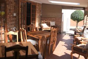 een restaurant met houten tafels en stoelen in een kamer bij Siesta B&B in Vryheid