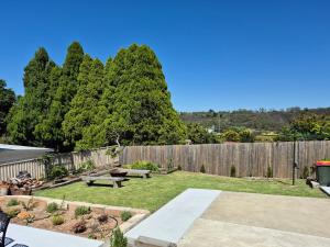 Un jardín con valla de madera y mesas de picnic. en Heart of Katoomba Semi 1 bedroom home, en Katoomba 7 fotos más