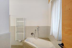 een badkamer met een bad en een douche bij New Opening Penthouse Zirm in Selva dei Molini +37 foto's