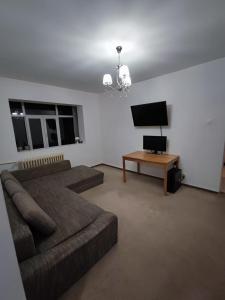 un soggiorno con divano e TV a schermo piatto di Ely Renting a Văleni