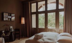 奈梅亨Boutique Hotel Blue - Quality Lodgings的一间卧室，里面有一张床和一扇大窗户。