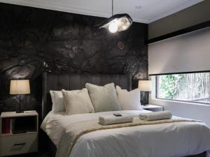 een slaapkamer met een groot bed met een zwarte muur bij Fossil Lane in Clarens