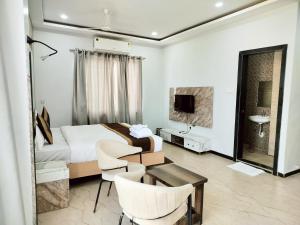 a hotel room with a bed and a table and chairs at Hotel Casa Del Sol in Raipur