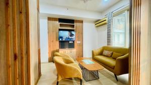 a living room with a couch and a table and a chair at Hotel The Grace Residency - Near Hotel Hyatt ,DLF MyPad, Gomtinagar, Lucknow in Lucknow
