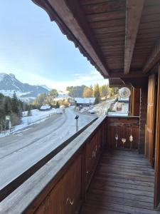 ein Balkon mit Blick auf eine Straße und Berge in der Unterkunft L'Auberge de la Comballaz in La Comballaz