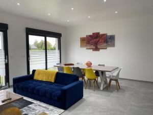 ein Wohnzimmer mit einem blauen Sofa und einem Tisch in der Unterkunft Gite de l'etoile in Rocroi
