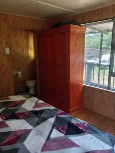 une chambre vide avec un lit et une fenêtre dans l'établissement Barberton Troop Cabin, à Barberton 1 autre photo