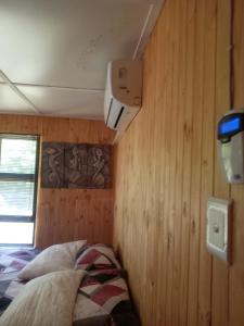 une chambre avec un lit dans un mur en bois dans l'établissement Barberton Troop Cabin, à Barberton