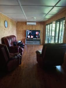 un salon avec deux canapés et une télévision dans l'établissement Barberton Troop Cabin, à Barberton