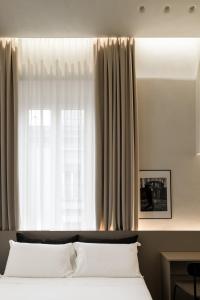 un lit avec des oreillers blancs devant une fenêtre dans l'établissement Iodis Relais, à Naples 20 autres photos