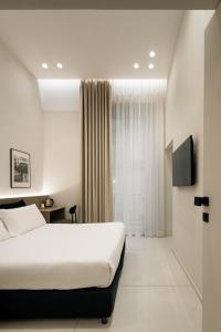 une chambre d'hôtel avec un lit et une télévision dans l'établissement Iodis Relais, à Naples