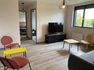 un soggiorno con divano, sedie e TV di Gîte 535 a Saulces-Monclin