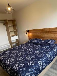 una camera con letto blu e bianco con testiera in legno di Gîte 535 a Saulces-Monclin