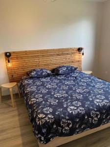 una camera da letto con un letto blu con testiera in legno di Gîte 535 a Saulces-Monclin